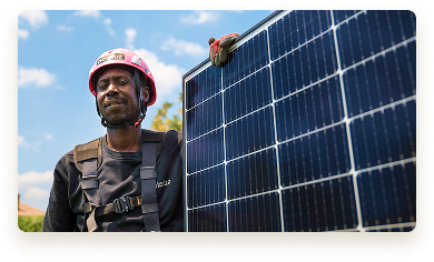 Técnico con equipo de seguridad sosteniendo un panel solar