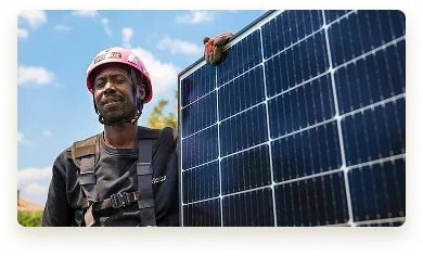 Técnico con equipo de seguridad sosteniendo un panel solar