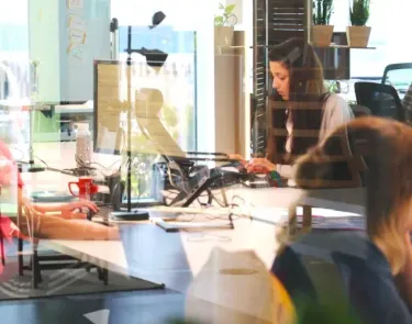Personas sentadas en escritorios en una oficina