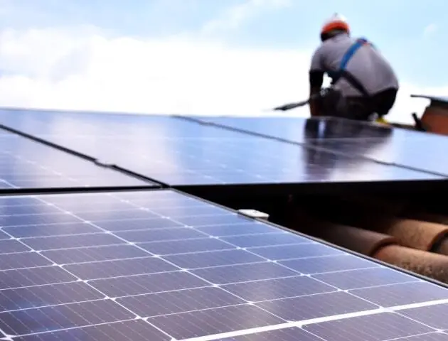 Imagen técnico instalador con panel solar. Tu pones el tejado. Nosotros la revolución