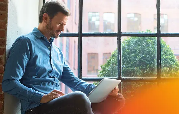 Man sitting with a tablet near a window