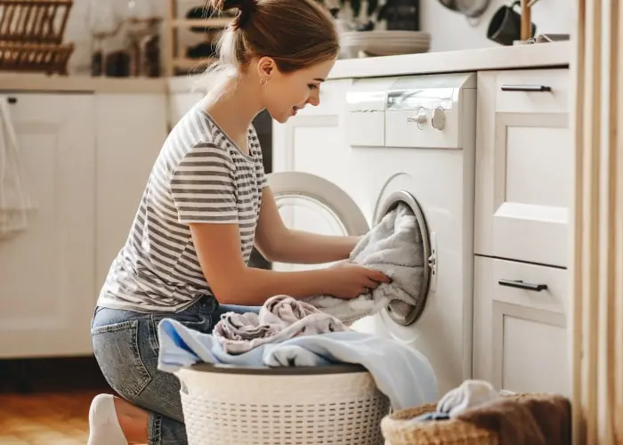A person washing clothes in a washing machine