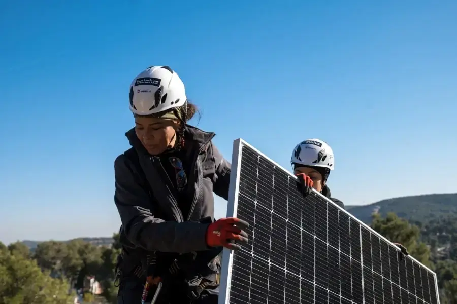 Dos personas trabajando juntas para instalar paneles solares.